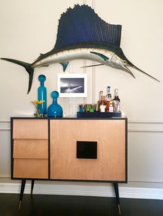 a fish sculpture on top of a wooden cabinet