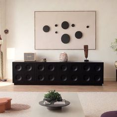 a living room filled with furniture and a large painting on the wall above an entertainment center