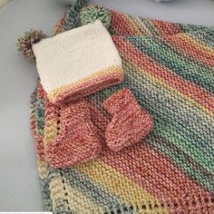 a knitted blanket with mittens and gloves on it