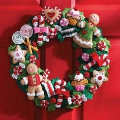 a christmas wreath is hanging on the front door with candy and candies around it