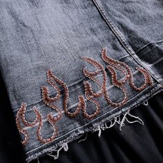 an old pair of jeans that have been stitched together with some thread on them