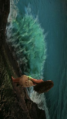 a man standing on top of a cliff next to the ocean