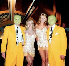 three people dressed in yellow and white posing for a photo with green man's