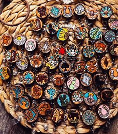 a basket filled with lots of different types of buttons on top of a wooden table