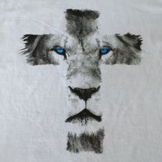 a cross with blue eyes and a lion's face on it is painted onto a white t - shirt