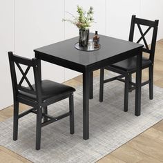 a black table and two chairs on a rug