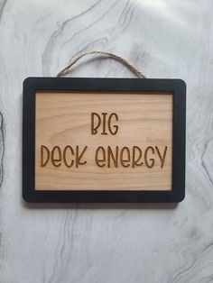 a wooden sign that says pig deck energy on the side of a white marble wall