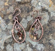 Hammered Copper with copper figure eights and flame colored crystal dangles. Come on handmade copper ear wires.Approximately 2" long from the top of the ear wire and 13/16" wideThese Earrings have been antiqued, polished and sealed.Sealed with Protectaclear ProtectaClear is a clear, protective coating that is tough enough to protect jewelry and is safe for wear against skin. ProtectaClear is practically invisible once applied and will seal and protect jewelry from tarnish, oxidation, and corrosi Colored Wire Jewelry, Bronze Teardrop Copper Earrings, Bronze Copper Teardrop Earrings, Copper Teardrop Dangle Earrings, Bronze Wire Wrapped Copper Earrings, Bronze Wire Wrapped Teardrop Earrings, Copper Earrings Handmade Ideas, Hand Forged Copper Wire Drop Earrings, Hand Forged Bronze Earrings With Copper Wire