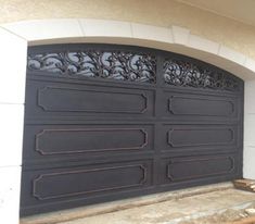 a large black garage door sitting on the side of a building