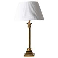 a gold lamp with a white shade on it