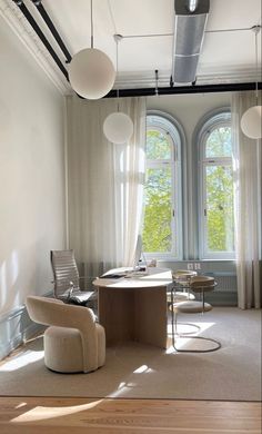 a living room filled with furniture and large windows