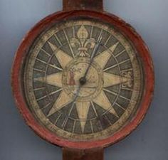 an old clock with a compass on it