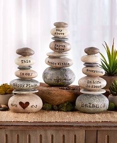 rocks stacked on top of each other with words written on them and succulents