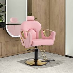 a pink chair sitting in front of a mirror on top of a wooden floor next to a plant