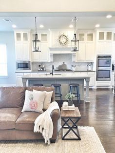 a living room filled with furniture next to a kitchen