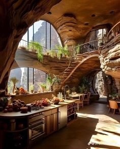 an indoor kitchen and dining area in a cave like building with spiral stairs leading up to the second floor