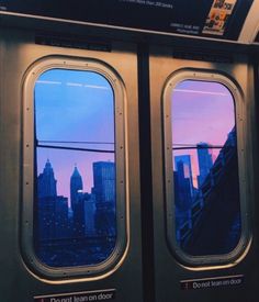 an airplane window with the city skyline seen through it's windows at dusk or dawn