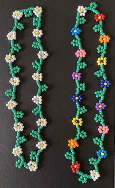 two necklaces made out of beads with flowers on the side and one beaded in different colors