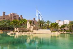 the water is green and clear in front of some buildings with palm trees around it