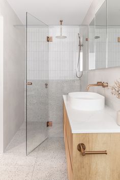 a bathroom with a sink, mirror and shower stall is shown in this image from the front view