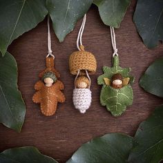 three little knitted acorns hanging from leaves