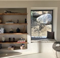 a room with some shelves filled with books and vases