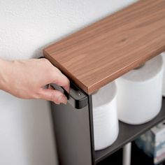 a person is holding the handle on a shelf