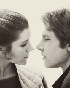 a young man and woman are facing each other with their faces close together, one is wearing a star wars costume