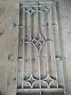 a metal grate sitting on top of a cement floor next to a window pane