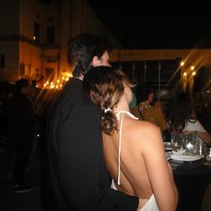 a man and woman standing next to each other at a dinner table