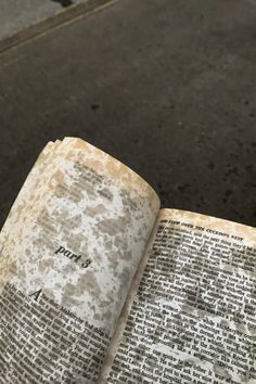 an open book sitting on top of a sidewalk