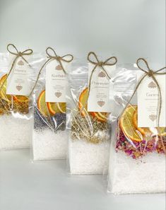 four bags filled with different types of salts and spices next to each other on a white surface