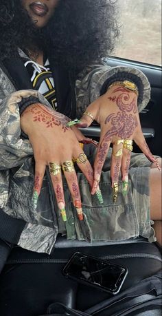 a woman with tattoos on her hands sitting in a car