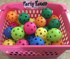 a pink basket filled with lots of colorful plastic balls