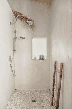 a white bathroom with a ladder in the shower