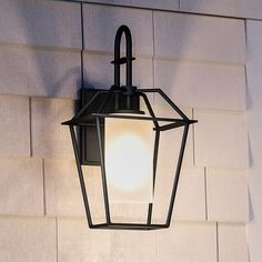 a light that is attached to the side of a building with a brick wall behind it