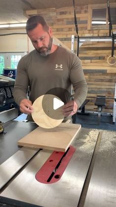 a man standing in front of a table sawing with a piece of wood on it