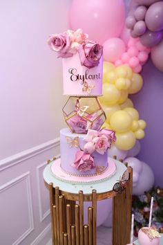 a three tiered cake sitting on top of a table next to balloons and streamers