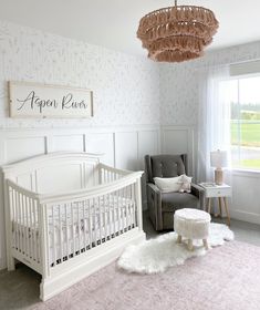 a baby's room with a white crib, chair and pink rug on the floor