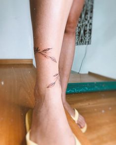 a woman's foot with a small tattoo on her left leg and an arrow in the middle