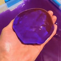 a person is holding a purple object in their hand and it looks like they are floating on the water