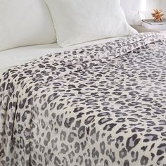 a leopard print bed spread with white pillows