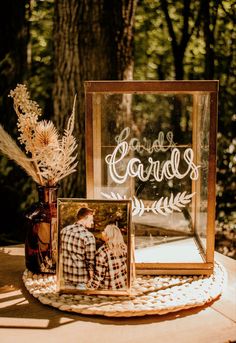 an image of a couple on their wedding day in front of a photo frame and flowers