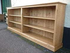 a wooden bookcase sitting on the side of a road