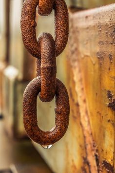 an old rusted metal chain hanging from the side of a building