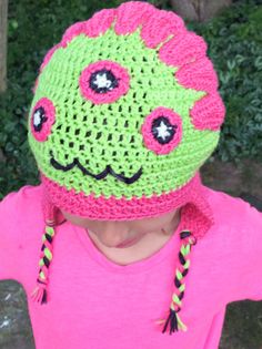 Dive headfirst into the joyous realm of Hazel, and say hello to the Hazel The Monster Crochet Hat. Crocheted with heart, this hat brings the playful spirit of a 7-year-old warmly to your doorstep. A SPLASH OF COLOR Unleash a whirlwind of colours! Much like Hazel, our crochet hat adores the dashing purple, inviting bright laughter and wide-eyed wonder. Chalk? Not a chance. But a vibrant, hand-crafted hat? Absolutely! TWIN-TASTIC Living with Henry, her mischievous twin, means boisterous laughter a Spiky Headband, Love Monsters, Monster Crochet, Monster S, Crochet Terminology, American Crochet, Bonnet Au Crochet, Monster Hat, Three Eyes