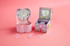 an open musical box on a pink background