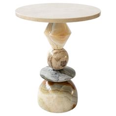 a small table with three stones stacked on top of each other and one stone sitting on top of it