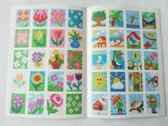 an open book with cross stitch designs on it's cover and the pages are lined in squares