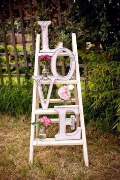 an old ladder is decorated with flowers and the word love